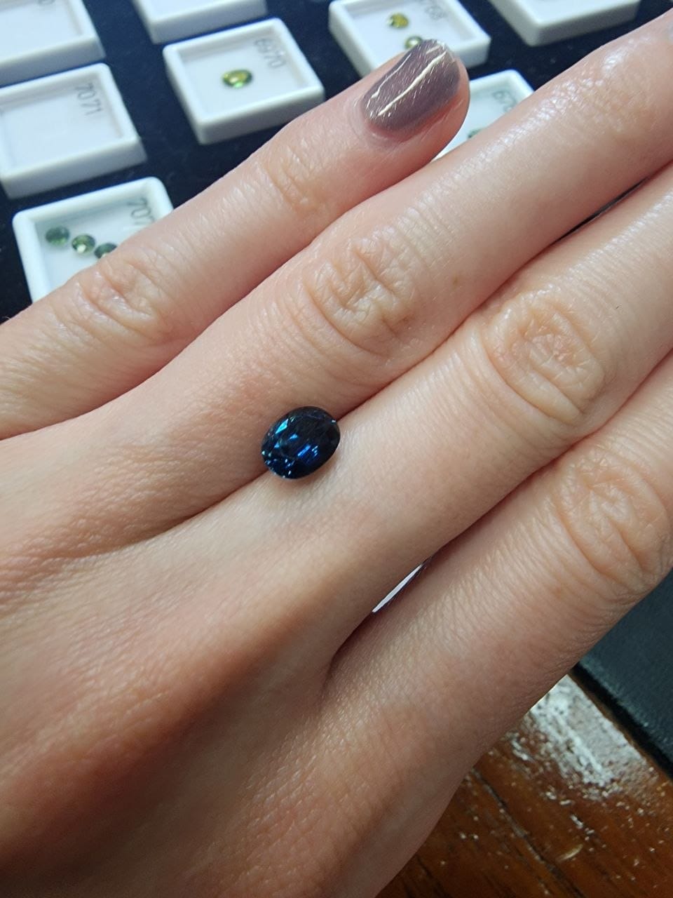 Blue Australian Sapphire 1.47ct Oval — actual stone, photographed on the hand for scale — Ministry of Gems (view 3)